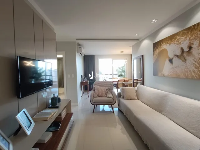 Sala de estar moderna com sofá e televisão em um imóvel no Brasil.