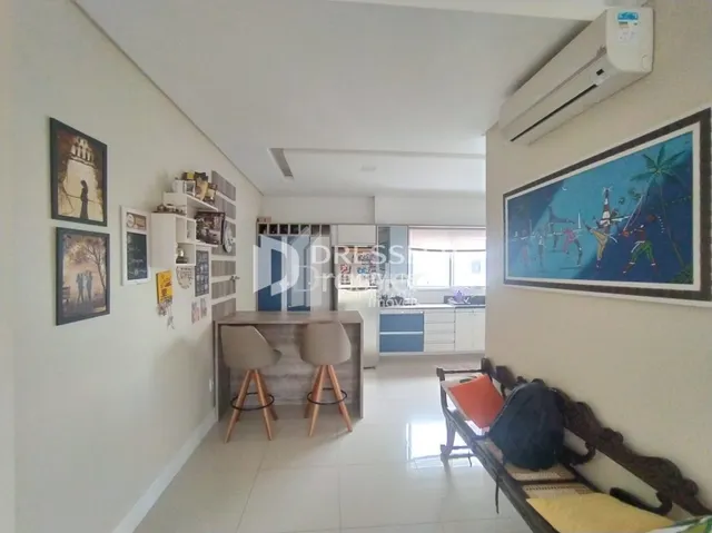 Ambiente interno claro com parede branca e decoração na sala.