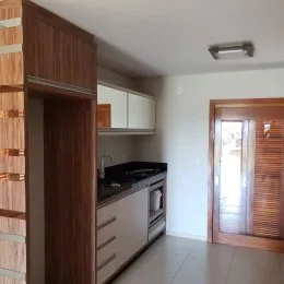 Foto interna de uma cozinha com armários e bancada em um imóvel em Lajeado.