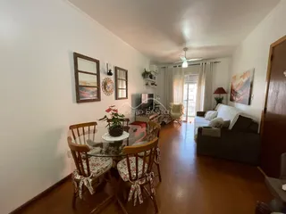 Sala de estar com mesa de jantar e sofá em ambiente claro.