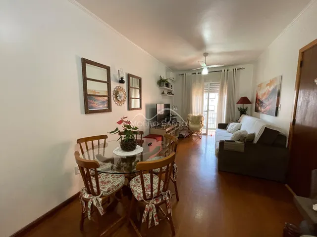 Sala de estar com mesa de jantar e sofá em ambiente claro.