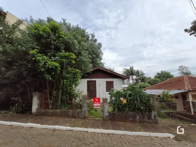 Fachada de uma residência na área de Lajeado, Brasil, parcialmente coberta por vegetação.