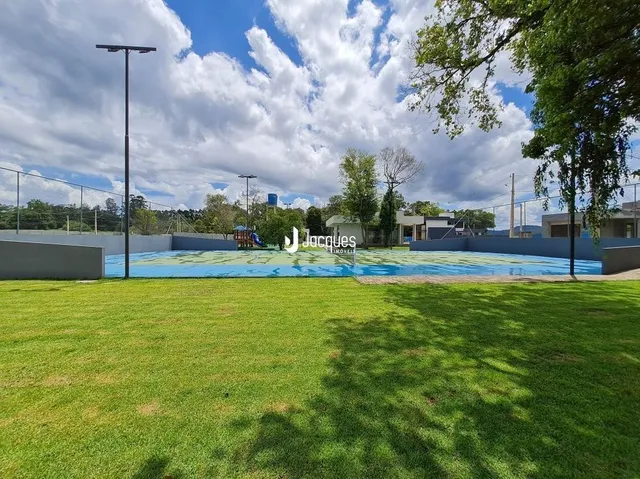 Um gramado verde com uma área de piscina ao fundo.