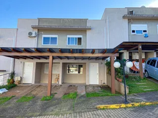 Fachada de uma residência em Lajeado, Brasil, mostrando a entrada e uma área coberta com garagem.