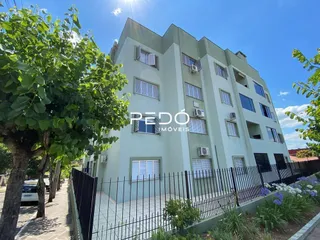 Fachada de um prédio residencial em Lajeado com cerca e jardim.