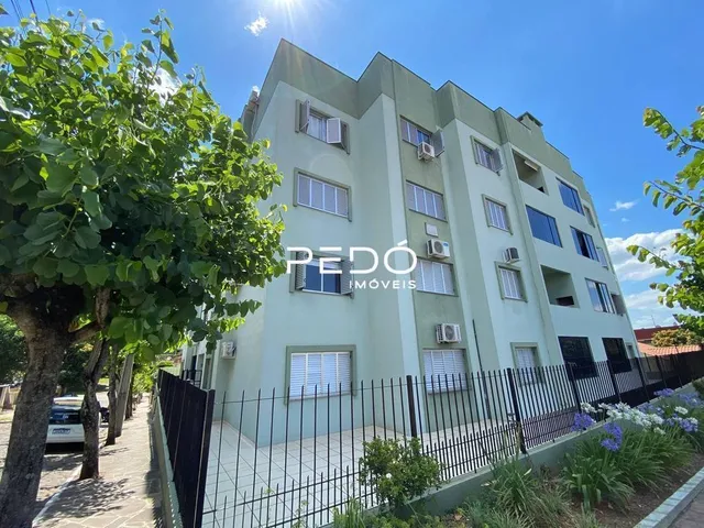 Fachada de um prédio residencial em Lajeado com cerca e jardim.