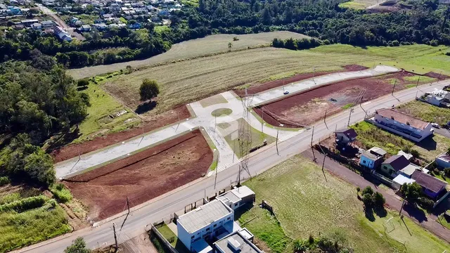Vista aérea de uma propriedade rural com áreas de terra e vegetação.