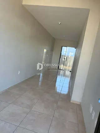 Corredor interno com piso de cerâmica claro.