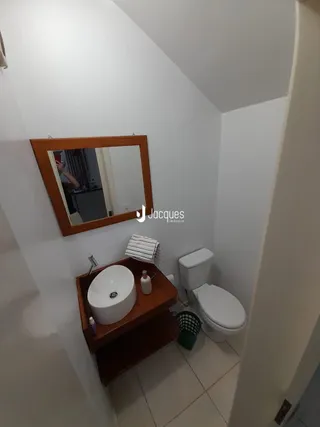 Foto de um banheiro interno com pia e vaso sanitário brancos.