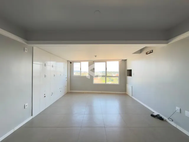Interior de um ambiente amplo com piso claro e armários embutidos.