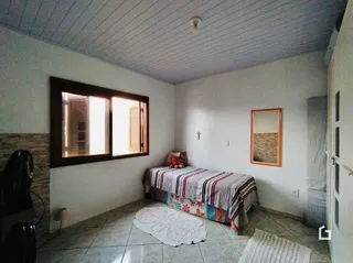Quarto com cama e piso de cerâmica na residência.