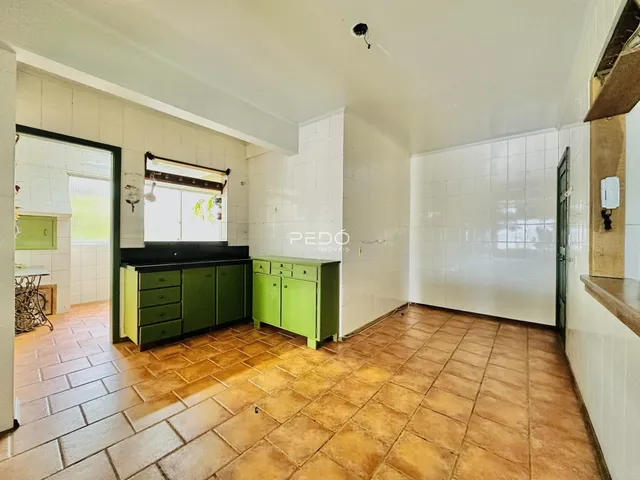 Imagem de uma cozinha com piso de cerâmica e armários verdes.