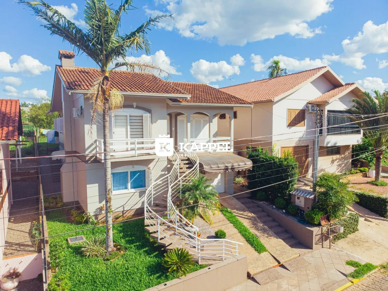 Fachada de uma casa residencial em Lajeado, Brasil, com jardim e acesso por escadaria.