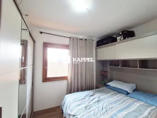 Quarto com cama e armário branco, com janela e cortinas.