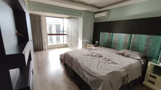 Um quarto com cama grande e janela mostrando vista urbana.