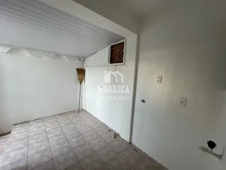 Interior de uma sala com piso de cerâmica e paredes brancas.
