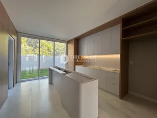Cozinha moderna com portas de vidro que dão acesso a um jardim externo.