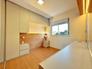 Uma cozinha moderna com armários brancos e piso de madeira clara.
