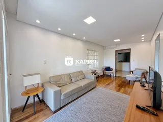 Sala de estar com sofá e piso de madeira clara.