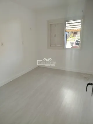Vista interna de um cômodo com piso claro e paredes brancas.