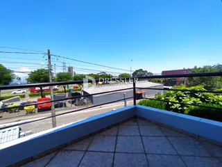 Vista da varanda com grade de segurança e paisagem urbana.