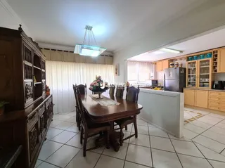 Imagem de um ambiente interno com mesa de madeira e armários.