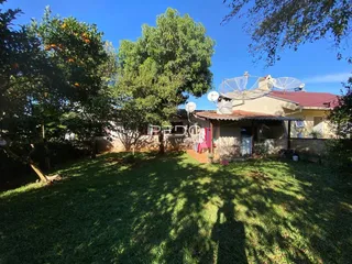 Fachada de uma casa em Lajeado, Brasil, com jardim e árvores ao redor.