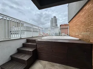 Foto de uma varanda com degraus de madeira e uma banheira branca.