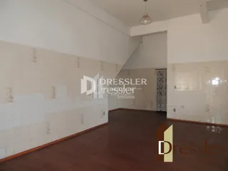 Hall de entrada com piso de madeira e paredes brancas.