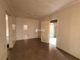 Vista interna de um ambiente com paredes brancas e piso de cerâmica.