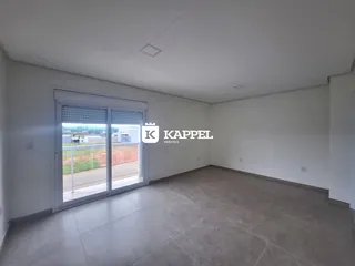 Sala ampla com porta de vidro que oferece vista para a paisagem externa.