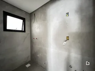 Vista de um canto de parede interna com uma janela e detalhes de instalação.