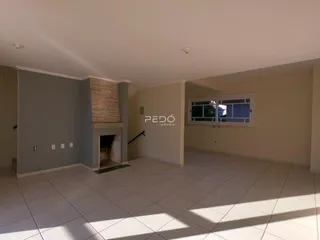 Ambiente interno com piso cerâmico e lareira em uma sala de estar.