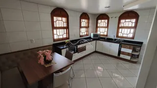 Sala de estar com mesa de madeira escura e janelas com caixilhos de madeira.