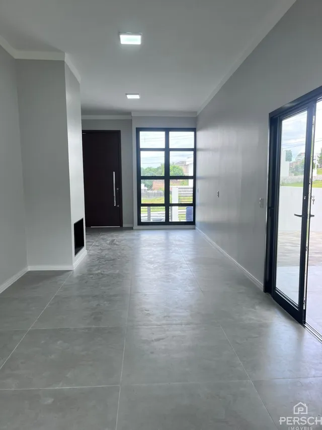 Corredor com piso claro e portas escuras em um imóvel.