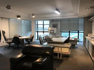 Uma sala de estar ampla com mobiliário moderno e grandes janelas.