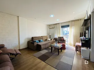 Sala de estar com sofá e piso de madeira.