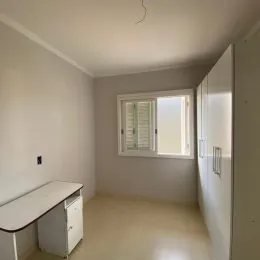 Quarto simples com paredes brancas e janela.