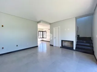 Corredor interno de uma residência com paredes cinzas e piso de cerâmica.