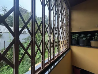 Vista da propriedade através de uma grade de ferro decorativa.