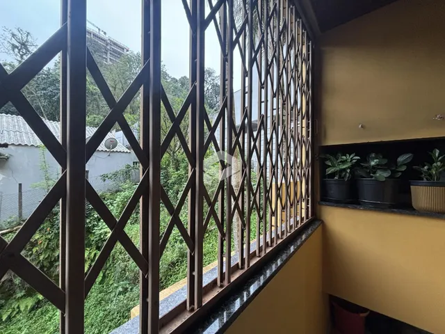 Vista da propriedade através de uma grade de ferro decorativa.