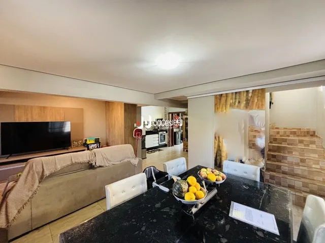 Sala de estar com sofá e televisão em um imóvel.