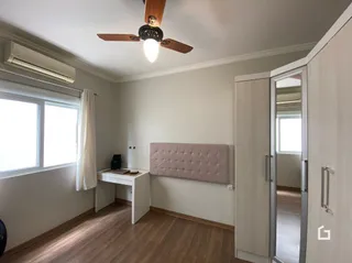 Quarto com armário embutido e piso de madeira.