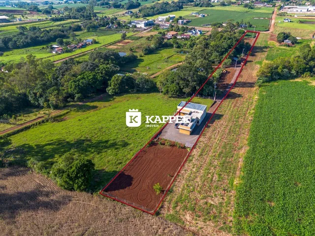 Vista aérea de uma propriedade rural em Lajeado, Brasil, mostrando campos agrícolas e uma edificação.