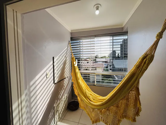 Vista interna de um corredor com janela e decoração de tecido amarelo.