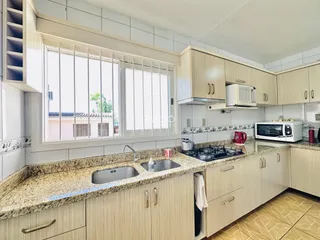 Cozinha com armários e bancadas de granito em um imóvel no Brasil.