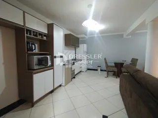 Sala de estar com sofá e piso de cerâmica clara.