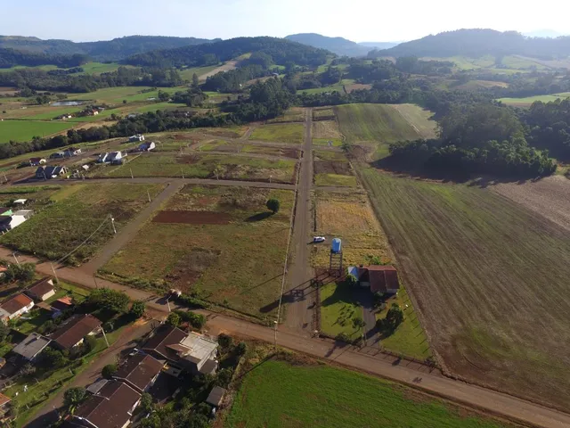 Vista aérea de uma propriedade rural com campos abertos e estradas de terra.