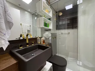 Banheiro moderno com bancada e box de vidro.