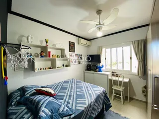 Quarto com cama e janela em ambiente residencial.